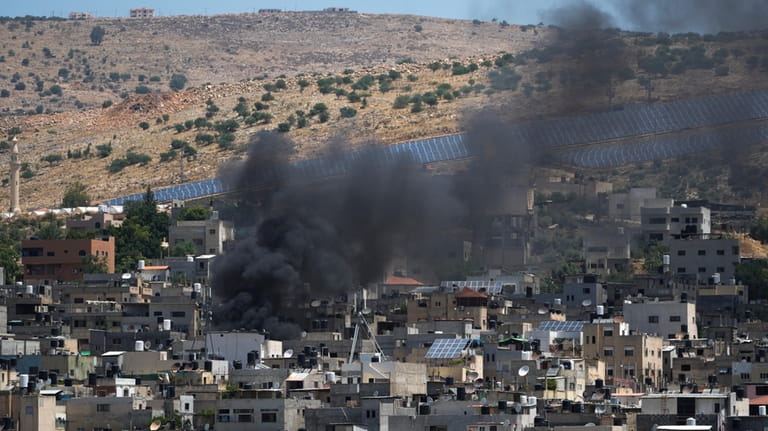 Smoke rises in the Palestinians Al Fara'a refugee camp in...