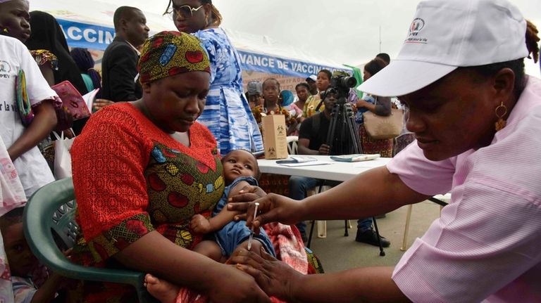 A health worker administers the malaria vaccine Oxford-Serum R21 to...