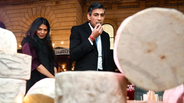Britain's Prime Minister Rishi Sunak samples a cheese next to...