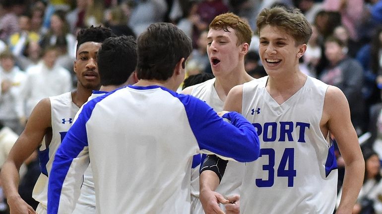 Dylan Trenaman of Port Washington, right, and teammates celebrate after...