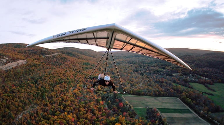 A hang glider takes in the autumn foliage above Ellenville,...