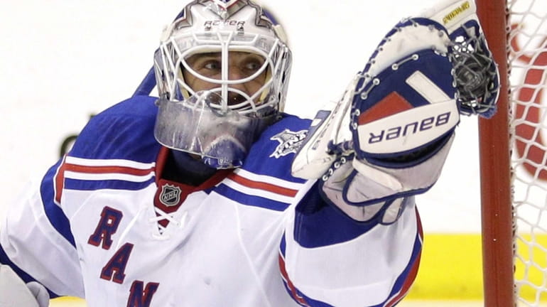 Rangers goalie Henrik Lundqvist gloves the puck while playing the...