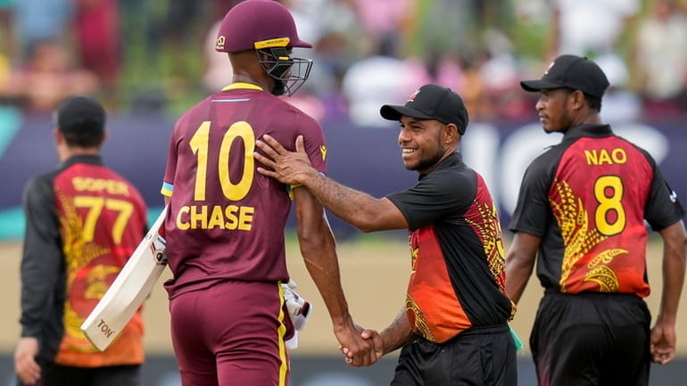 Papua New Guinea's Sese Bau congratulates West Indies' batsman Roston...