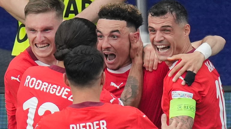 Switzerland's Ruben Vargas, center, celebrates with teammates after scoring his...
