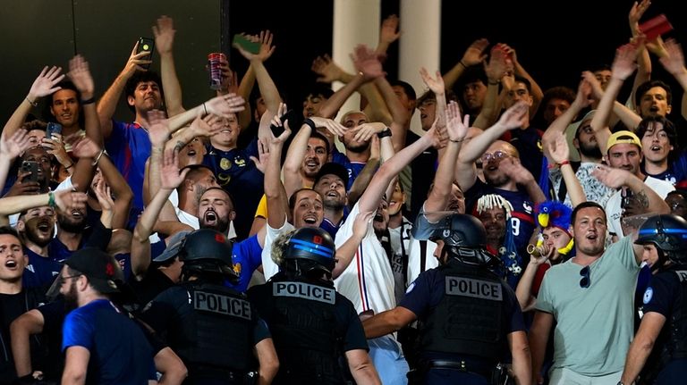 Police officers separate France and Argentina fans at the end...