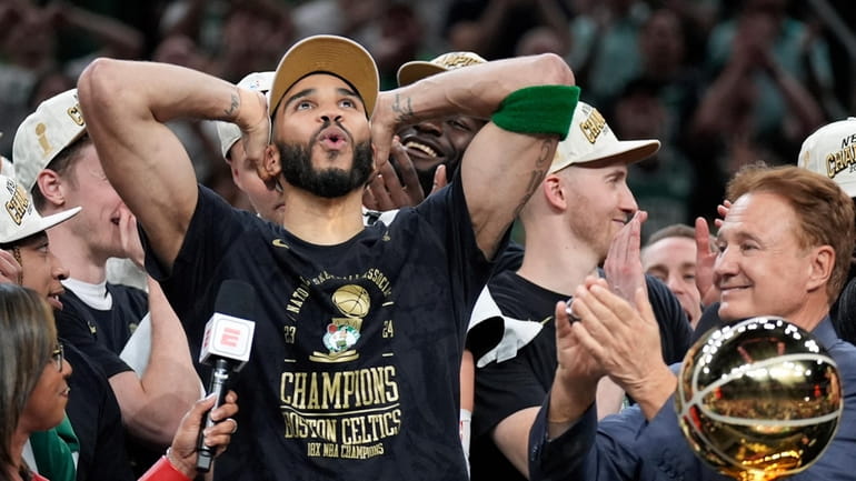 Boston Celtics forward Jayson Tatum, left, celebrates next to Celtics...