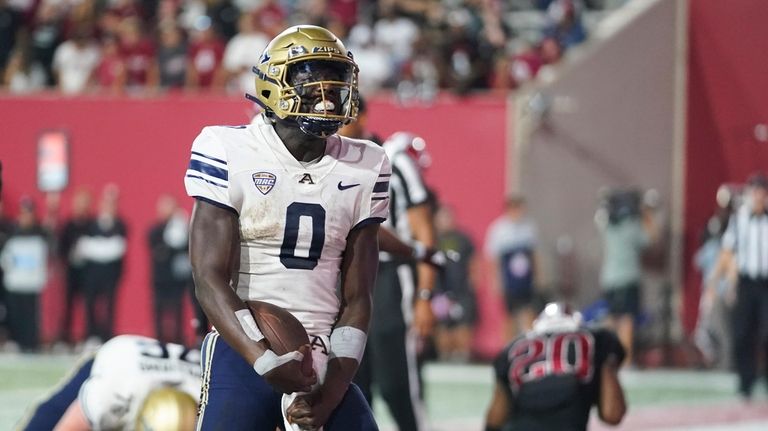 Akron quarterback DJ Irons celebrates a rushing touchdown against Indiana...