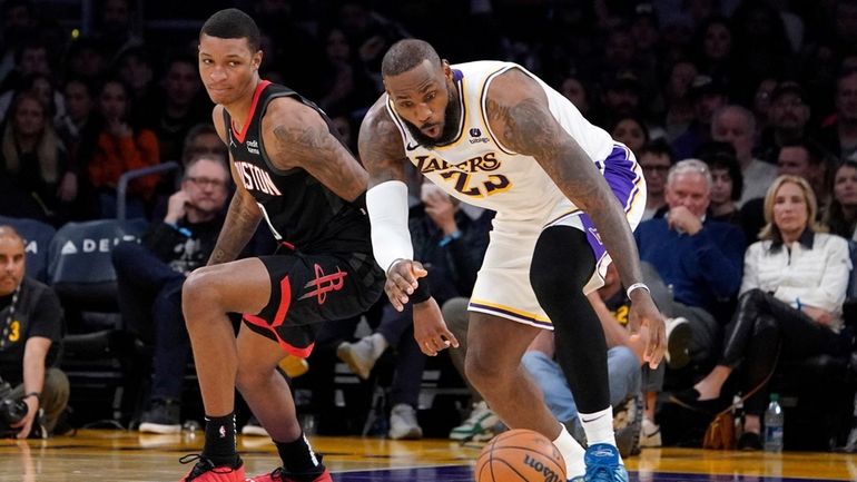 Los Angeles Lakers forward LeBron James, right, grabs a loose...