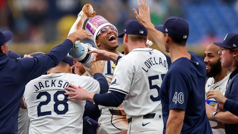 Tampa Bay Rays' Richie Palacios, center, is congratulated by teammates...