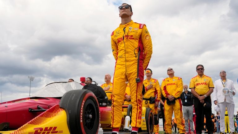 Driver Alex Palou stands with his team before an IndyCar...