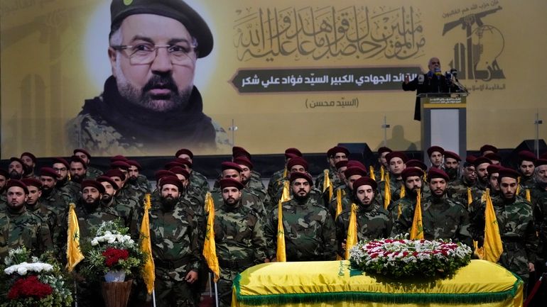 Hezbollah fighters stand behind the coffin of their top commander...