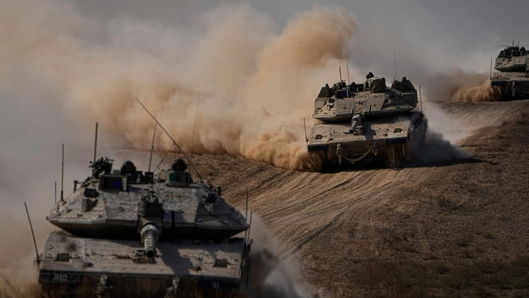 Israeli tanks head towards the Gaza Strip border in southern...