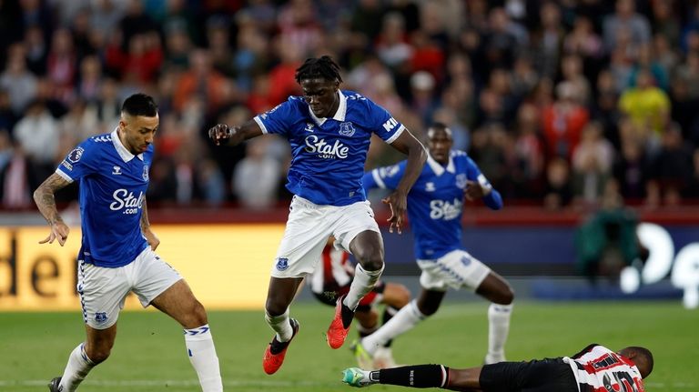 Everton's Dwight McNeil, left and Amadou Onana, centre, vie for...