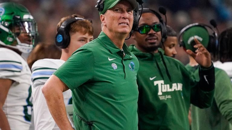 Tulane head coach Willie Fritz , center, looks on from...