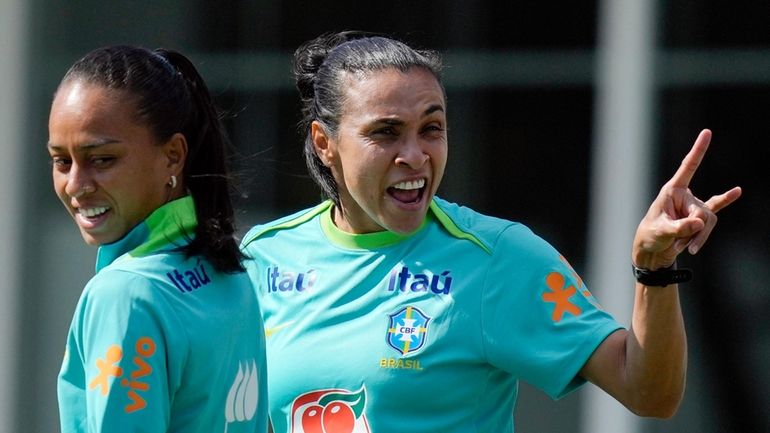 Brazilian soccer players Marta, right, and Adriana arrive for practice...