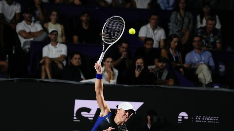 Iga Swiatek, of Poland, serves to Aryna Sabalenka, of Belarus,...