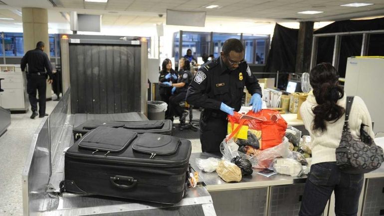 Customs officer Dennis Torrey confiscates dried cowskin from a passenger...