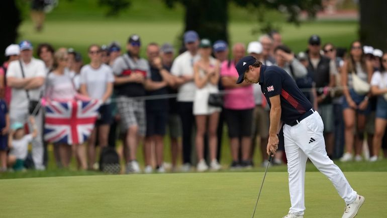 Matthew Fitzpatrick, of Britain taps in on the 5th green...