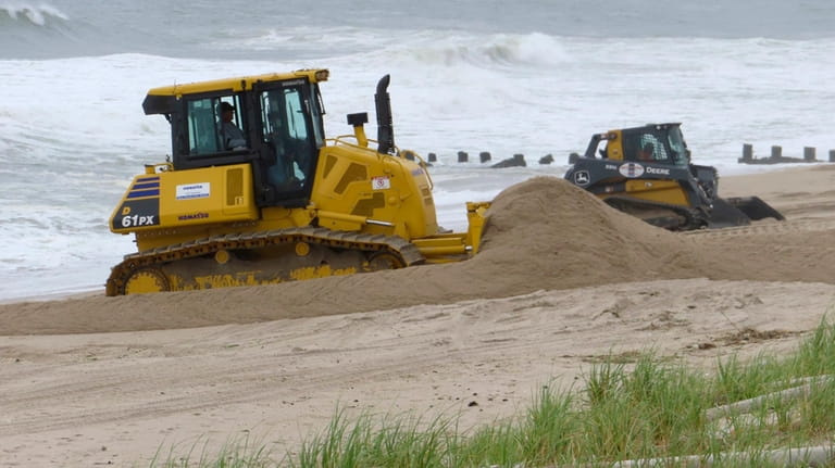 Bulldozers push sand on the beach in Bay Head, N.J....