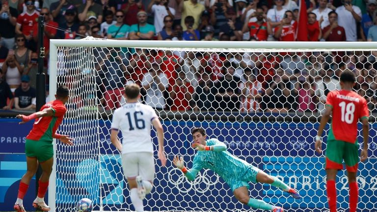 Morocco's Soufiane Rahimi scores the opening goal from the penalty...