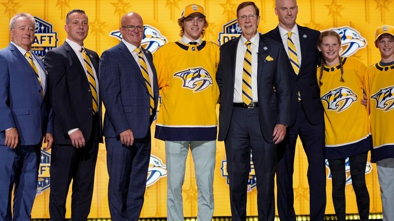 Tanner Molendyk, center left, poses with Nashville Predators officials after...