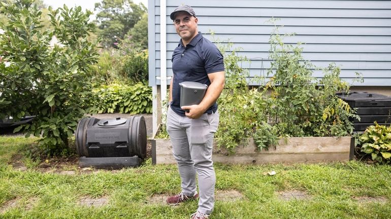 Joseph Farhangian next to the composting bin outside of his...