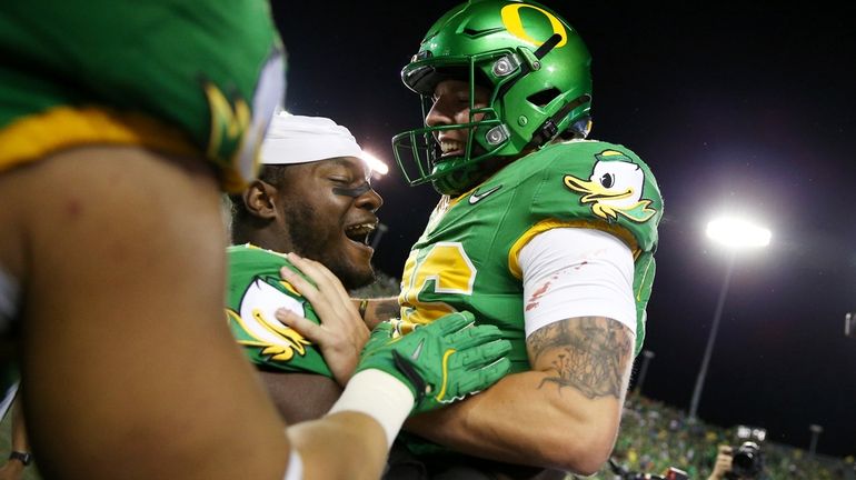 Oregon place kicker Atticus Sappington (36) is congratulated by teammates...