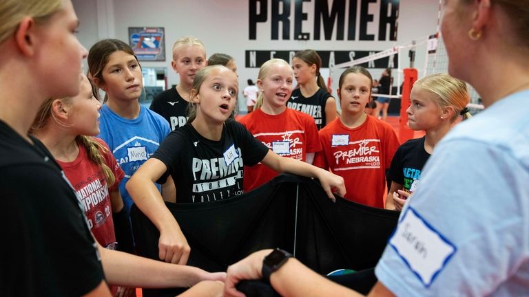 Lily Borgmann, 11, center, huddles with her team between drills...