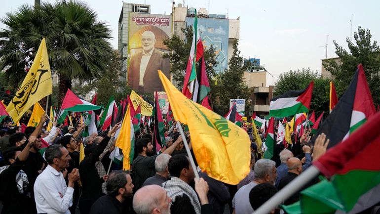 Iranian protesters wave Iranian, Palestinian and Lebanon's militant Hezbollah group...