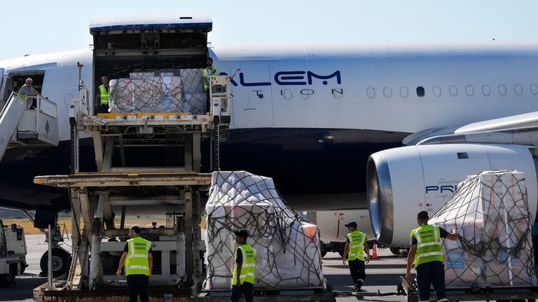 Lebanese airport workers unload medical aid boxes, which are part...