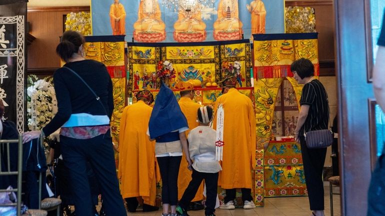 Buddhist monks chant at the memorial service Tuesday in Flushing for...