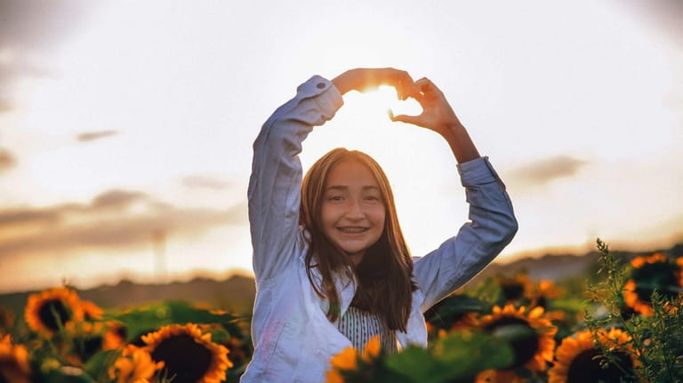 Megan Morris-Gray, of Port Jefferson Station, makes the "love heart"...