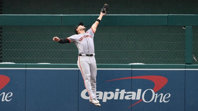 San Francisco Giants left fielder Michael Conforto leaps up to...