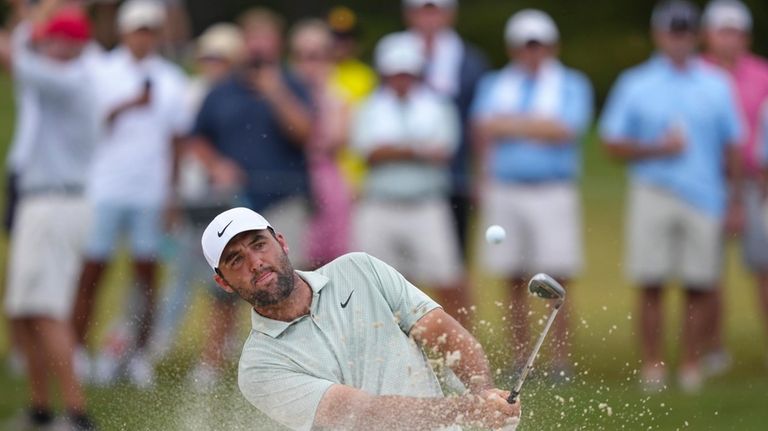 Scottie Scheffler hits from a bunker on the sixth hole...