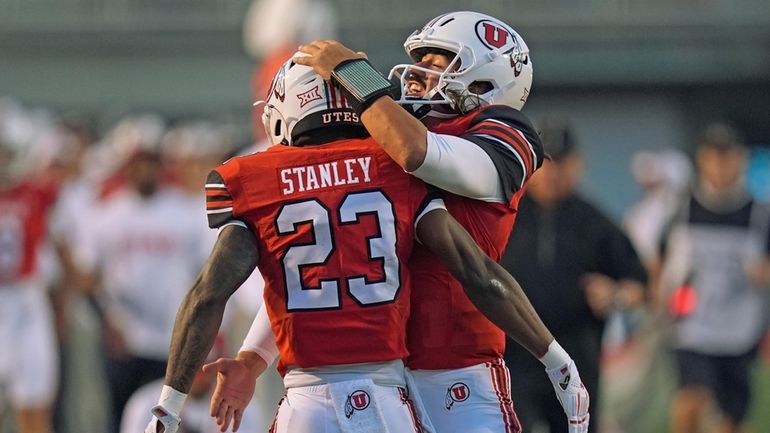 Utah quarterback Cameron Rising, right, celebrates with running back Dijon...