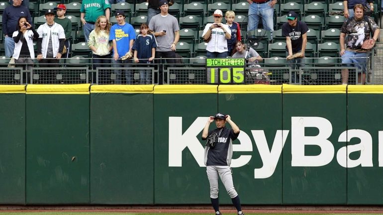 Yankees outfielder Ichiro Suzuki adjusts his sunglasses as he stands...