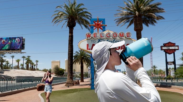 Dean Leano takes a water break while photographing tourists at...