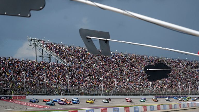 With rain clouds approaching, drivers compete during a NASCAR Cup...