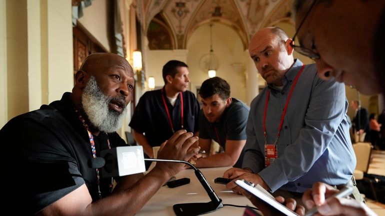 Houston Texans head coach Lovie Smith, left, speaks to journalists...