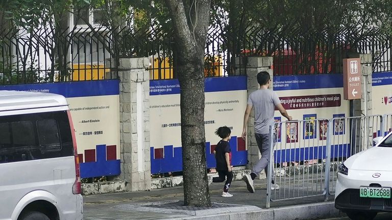 People walk past the Shenzhen Japanese School in Shenzhen, China...