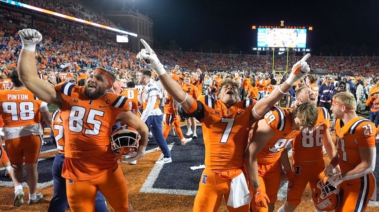 Illinois players celebrate the team's 23-17 upset win over Kansas...