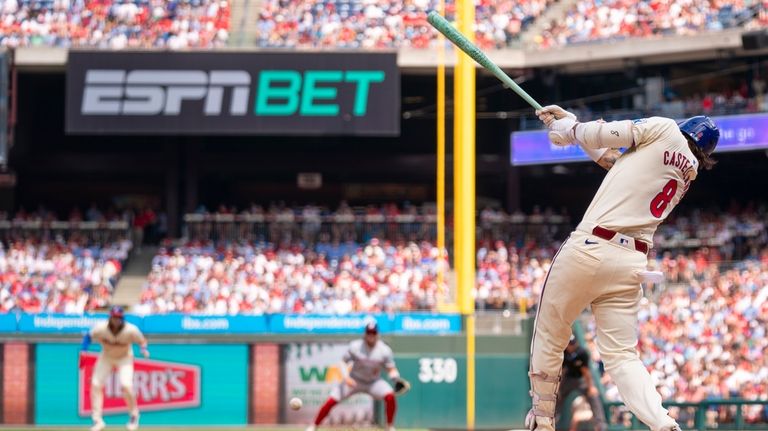 Philadelphia Phillies' Nick Castellanos hits a single to score Trea...