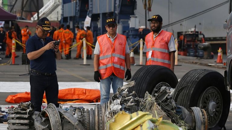 Officials inspect an engine recovered from the crashed Lion Air...