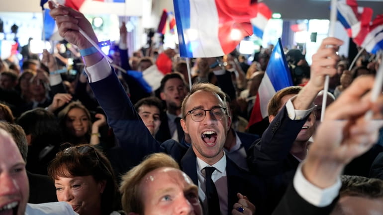 Supporters of French far-right National Rally react at the party...