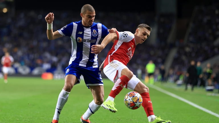 Porto's Pepe, left, vies for the ball with Arsenal's Leandro...