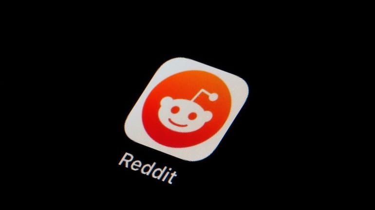 The Reddit app icon is seen on a smartphone on...