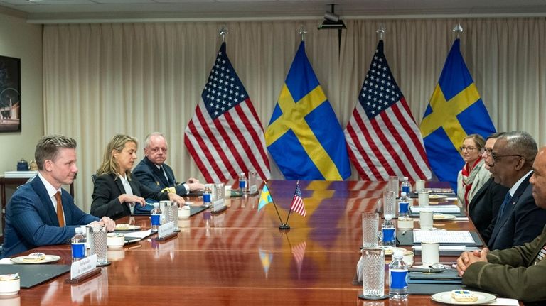 Defense Secretary Lloyd Austin, right, speaks during a meeting with...