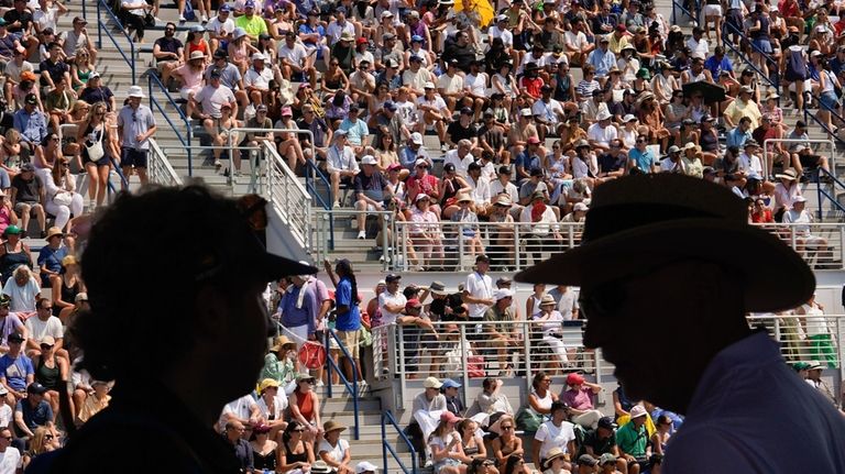 Tennis fans move in and out of their seats during...