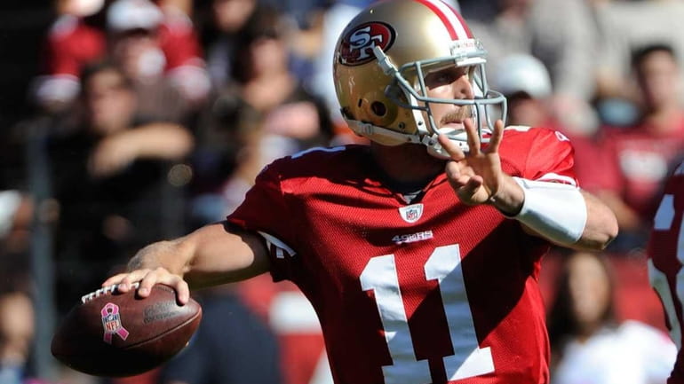 Alex Smith of the San Francisco 49ers drops back to...