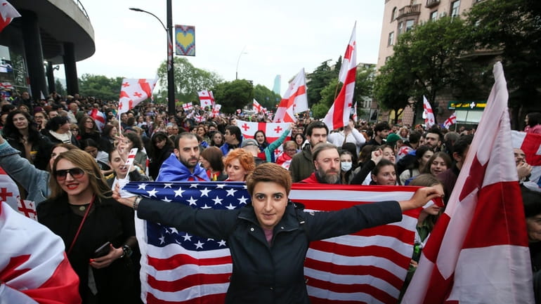 Demonstrators with Georgian national US flags rally during an opposition...